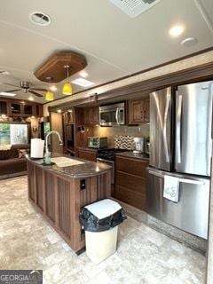 kitchen with dark countertops, visible vents, open floor plan, appliances with stainless steel finishes, and a sink