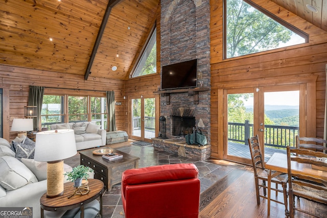 living room featuring wooden walls, beam ceiling, wooden ceiling, a fireplace, and wood finished floors