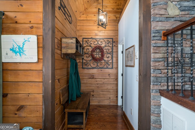 interior space with dark wood-style floors, lofted ceiling, and wood walls