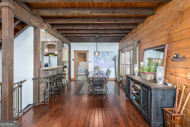 unfurnished dining area featuring beam ceiling, wood ceiling, dark wood-style flooring, and wood walls