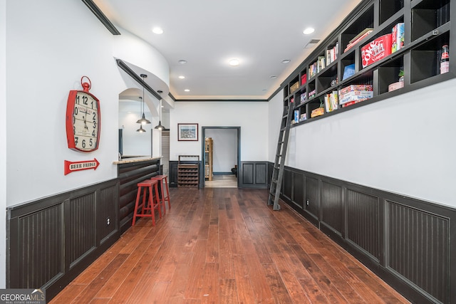 hallway featuring recessed lighting, wainscoting, and dark wood-style flooring