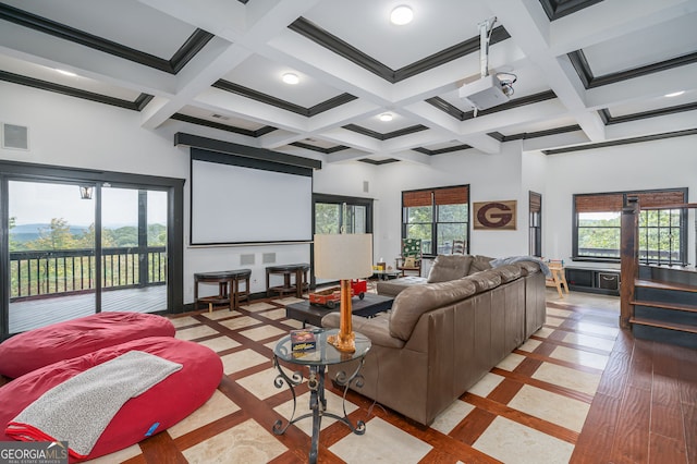 cinema room with baseboards, beam ceiling, coffered ceiling, and a high ceiling