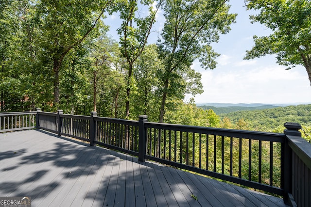 wooden terrace featuring a view of trees