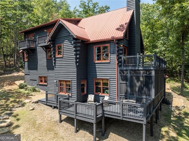 1363 Foxhound Trl NE, Ranger, GA 30734 - back of house with a chimney, a balcony, a metal roof, and a wooden deck