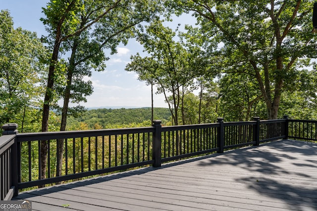 wooden terrace featuring a forest view