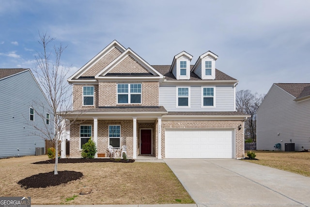 craftsman-style home featuring brick siding, cooling unit, an attached garage, and driveway