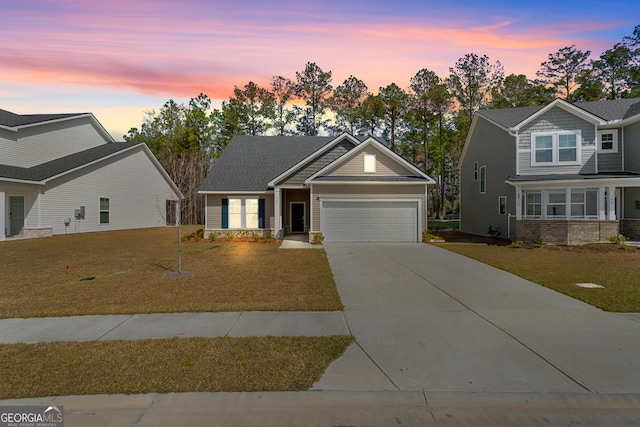 craftsman-style home with an attached garage, concrete driveway, and a yard