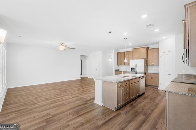 kitchen featuring a sink, wood finished floors, open floor plan, stainless steel appliances, and ceiling fan