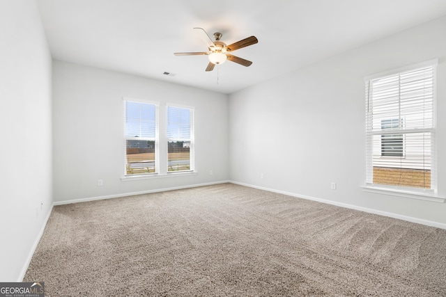 unfurnished room featuring a ceiling fan, visible vents, carpet floors, and baseboards