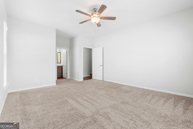 unfurnished bedroom with connected bathroom, a ceiling fan, baseboards, and carpet floors