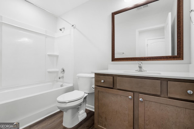 bathroom featuring visible vents, toilet, wood finished floors,  shower combination, and vanity