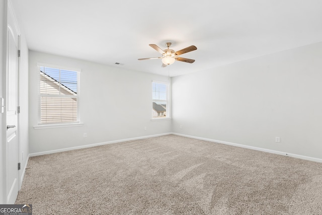 spare room with visible vents, carpet flooring, a ceiling fan, and baseboards