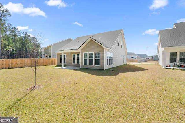 rear view of property with a yard, a patio area, and a fenced backyard