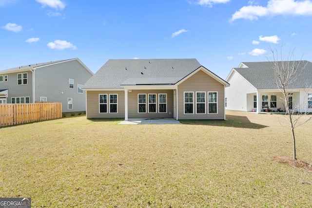 rear view of property with a patio area, a lawn, and fence