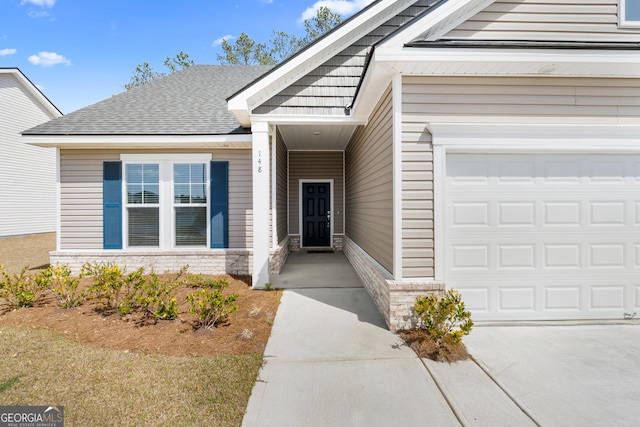 property entrance featuring concrete driveway, stone siding, and roof with shingles