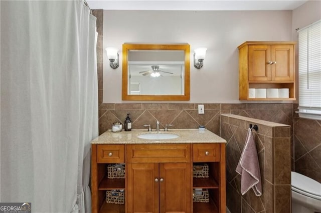 full bathroom with vanity, tile walls, toilet, and ceiling fan