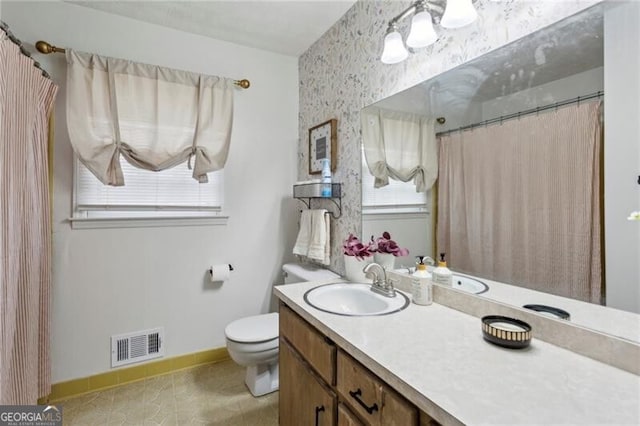 bathroom featuring vanity, baseboards, visible vents, tile patterned floors, and toilet