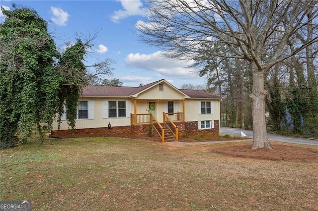 ranch-style house with a front yard and brick siding