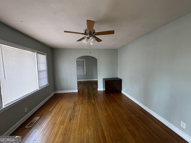 empty room with baseboards, hardwood / wood-style flooring, visible vents, and a textured ceiling