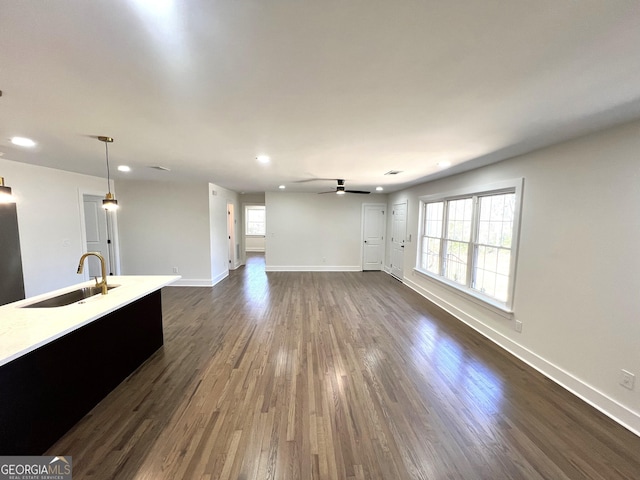 unfurnished living room featuring a ceiling fan, a sink, dark wood-style floors, recessed lighting, and baseboards