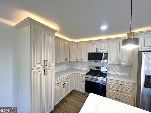 kitchen featuring light stone counters, dark wood-style floors, tasteful backsplash, and appliances with stainless steel finishes