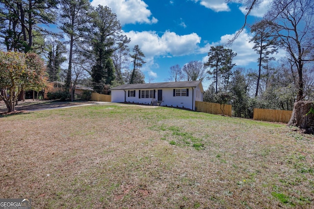 view of front of home with a front lawn and fence