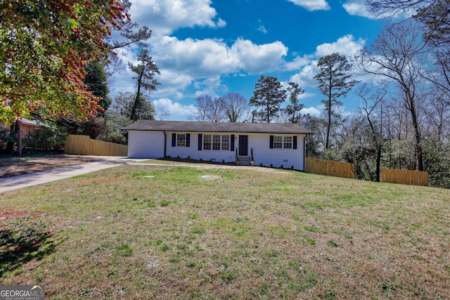 ranch-style house with driveway, a front yard, and fence