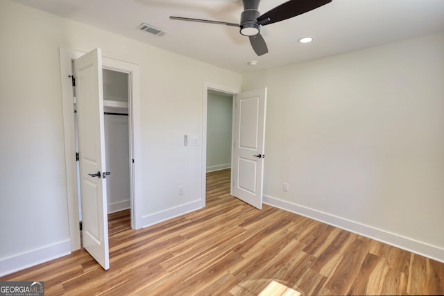 unfurnished bedroom with light wood-style flooring, visible vents, baseboards, and a closet