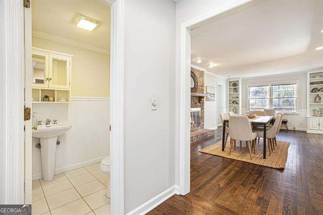 dining area featuring built in features, crown molding, and wood finished floors