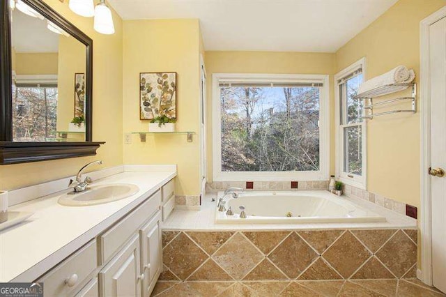 bathroom featuring a wealth of natural light, vanity, and a whirlpool tub