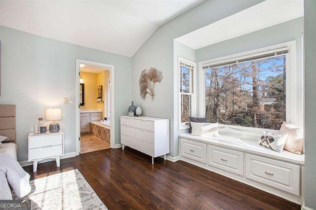 bedroom featuring ensuite bath, vaulted ceiling, dark wood-style floors, and baseboards