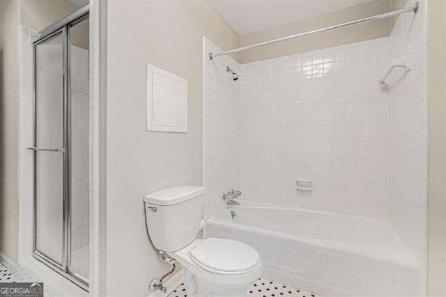 bathroom with tile patterned flooring, toilet, and bath / shower combo with glass door