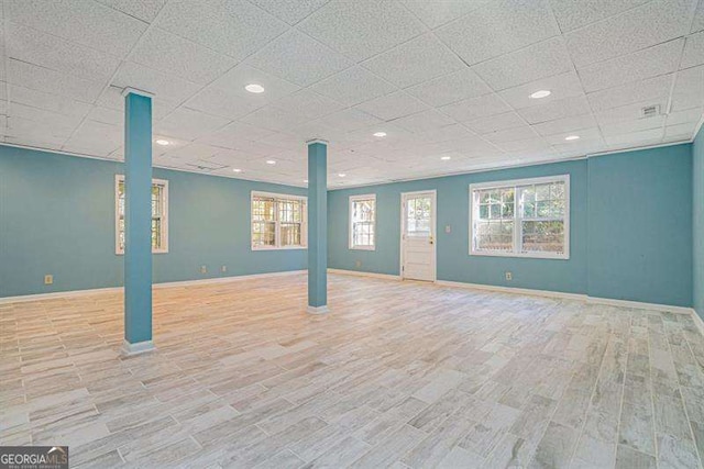 interior space featuring baseboards, plenty of natural light, and wood finished floors