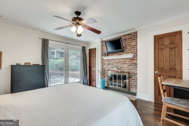 bedroom featuring access to exterior, a brick fireplace, crown molding, french doors, and dark wood-style floors