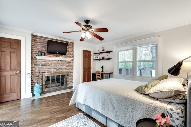 bedroom featuring a ceiling fan, crown molding, a brick fireplace, and wood finished floors