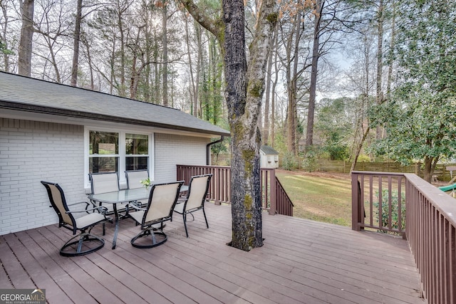 wooden deck featuring a yard, outdoor dining area, an outdoor structure, and fence