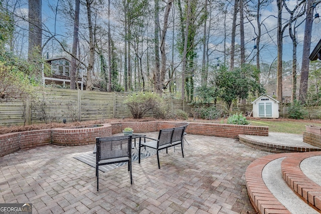 view of patio / terrace featuring an outdoor structure, a storage unit, and a fenced backyard