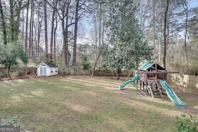 view of yard with a fenced backyard, a shed, a playground, and an outdoor structure