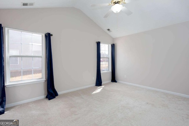 carpeted empty room featuring visible vents, baseboards, lofted ceiling, and a ceiling fan