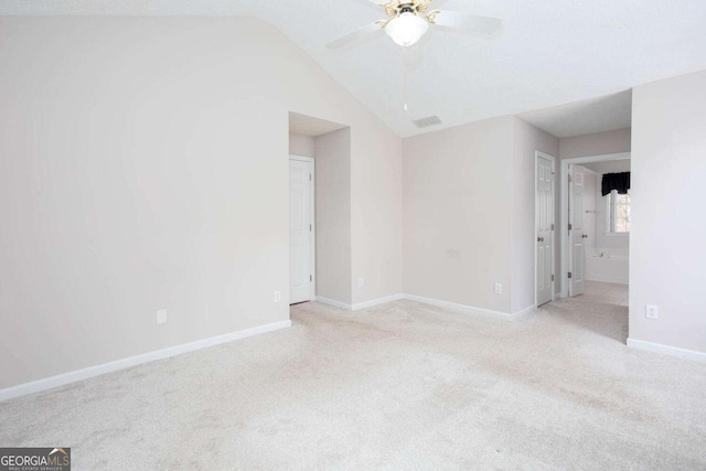 spare room with light colored carpet, baseboards, lofted ceiling, and ceiling fan