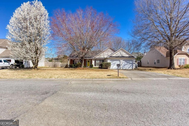 view of front of house with aphalt driveway, a front yard, and an attached garage