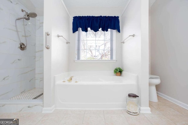 bathroom with tile patterned floors, a garden tub, toilet, tiled shower, and baseboards