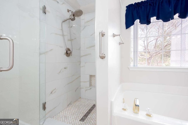 bathroom with a stall shower and a garden tub