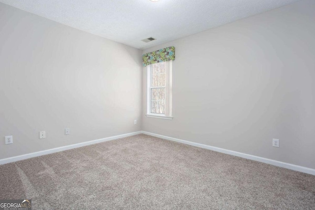 unfurnished room featuring visible vents, baseboards, carpet floors, and a textured ceiling