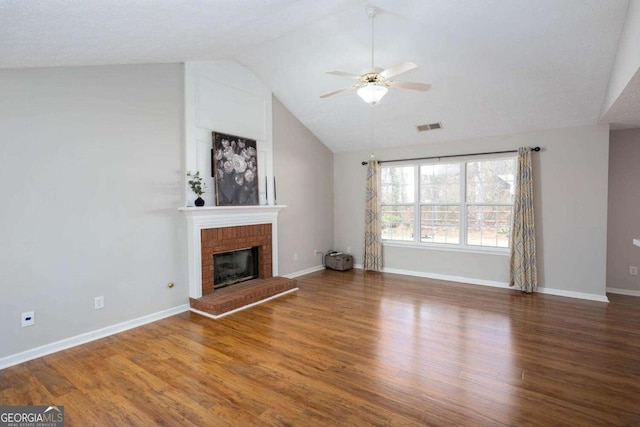 unfurnished living room featuring visible vents, a fireplace, a ceiling fan, and wood finished floors