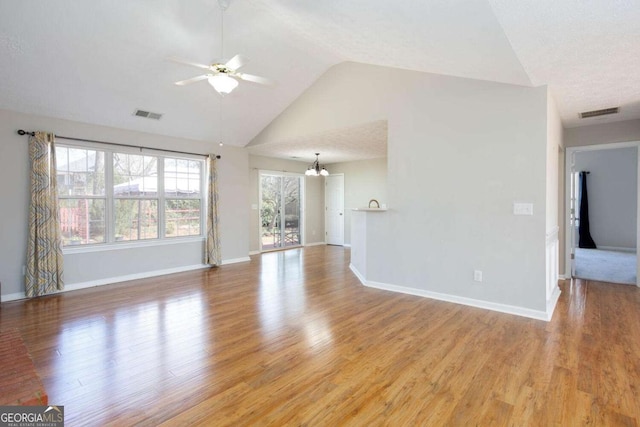 unfurnished living room with ceiling fan with notable chandelier, visible vents, light wood finished floors, and baseboards