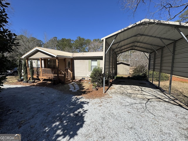 manufactured / mobile home with a detached carport, a porch, metal roof, crawl space, and driveway