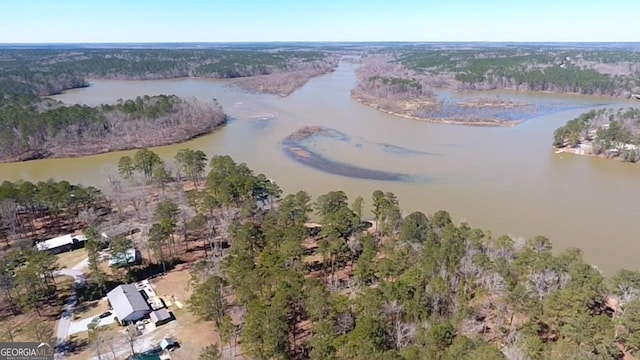 aerial view featuring a wooded view and a water view