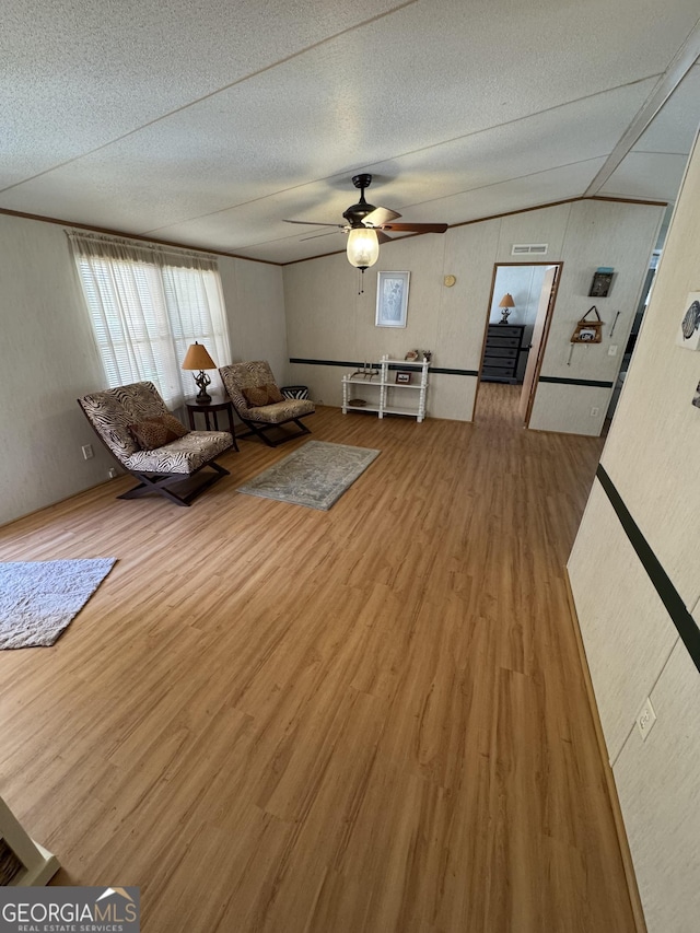 unfurnished room with ceiling fan, lofted ceiling, a textured ceiling, and wood finished floors