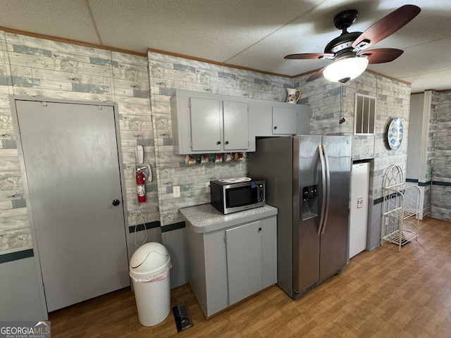 kitchen with visible vents, a textured ceiling, stainless steel appliances, light wood-style floors, and ceiling fan